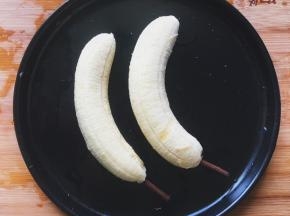将香蕉去皮，底部插上饼干棒