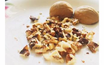 将核桃剥壳取出核桃肉，用擀面杖擀成大颗粒的核桃肉