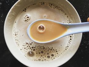 将咖啡加少许开水搅拌融化，加入一勺炼乳