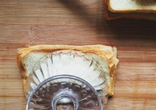 然后对折用小碗用力扣住使吐司粘合，去掉多余的吐司