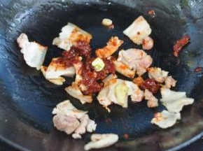 留底油，放入五花肉，放入葱，姜，蒜，郫县豆瓣酱。
