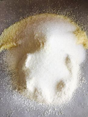 取一张油纸，将杏仁粉，低粉过筛，加入砂糖，用手把它们混合到一起