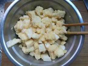 把切好的馒头丁放进蛋液里，拌匀，让每一块馒头都裹上蛋液。