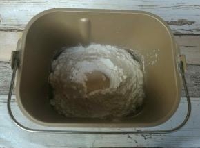 所有材料除黄油外按照先液体后固体，中间挖坑放酵母的顺序全部放入面包桶。