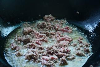 锅中倒入适量的菜籽油，等油熟烫加入牛肉小火慢炒出香。