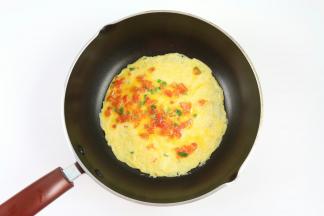 油热后，加入二分之一西红柿鸡蛋液，薄薄的铺在锅上，小火煎熟。