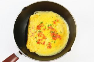 接着倒入剩下的鸡蛋液，倒在鸡蛋卷的另一头，小火加热。