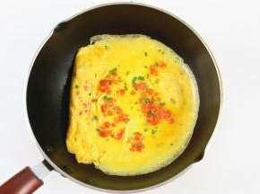 接着倒入剩下的鸡蛋液，倒在鸡蛋卷的另一头，小火加热。
