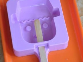 将雪糕模具放在平盘上，插入雪糕棍。