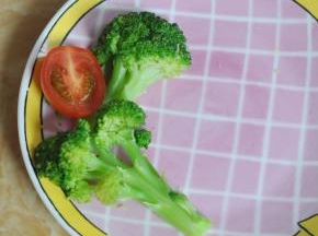 将西兰花切开，错落摆在盘中，再放半个圣女果在中间。