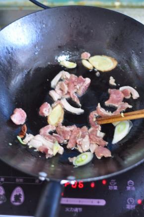 锅里倒入油，放入花椒、大料，放入腌好的肉翻炒，加入葱、姜、蒜。