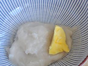 等糯米团不烫手时，放入黄油揉匀。