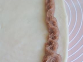 在糯米皮的一端，挤上一条芋头馅。