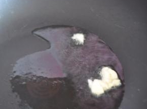 锅里倒入橄榄油，放入蒜片爆香。