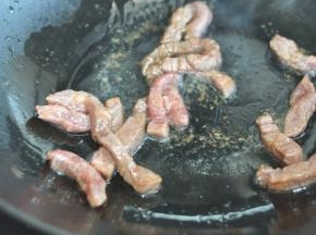 锅中留底油，放入牛排肉煸炒变色。