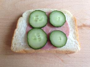 吐司片上涂沙拉酱，放上一片火腿片，黄瓜片