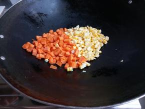 热锅下油，加胡萝卜丁和玉米粒