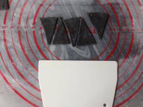 小面团发酵10分钟左右可以了，将黑色面团擀簿，擀成长方形，如图切成梯形，这个梯形的其中一边很短的