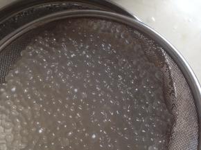 再重复这个步骤一次，煮好的西米已经呈完全透明状了。西米不宜久煮，就采用焖熟的方式。再用冷开水冲洗两三次，备用