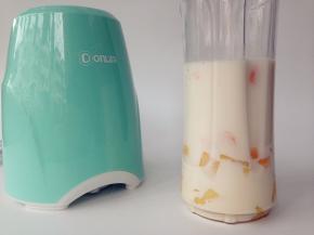 芒果肉、牛奶、方糖放进便携式果汁机的杯子里