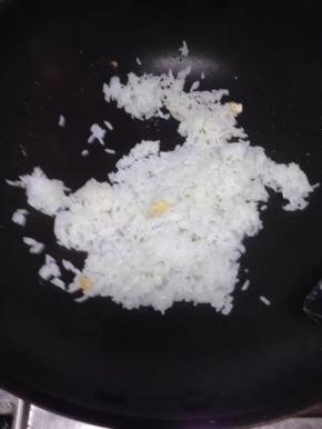 然后把米碗倒入锅里，加少量的水弄散翻炒。（这米饭是昨晚的，所以要放少许水，以免太干）