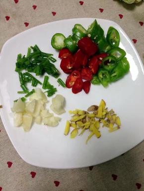 把青红杭椒洗净切小段，蒜略拍，姜切碎，葱切小段。