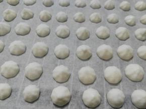 在铺了油纸的烤盘上挤出小圆粒面糊。全部挤好，就可以准备烘烤了（拌好的面糊足够浓稠的话，挤好的小圆粒应该是饱满圆润的。如果你的面糊太稀，挤出来就会很扁）。