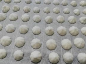 在铺了油纸的烤盘上挤出小圆粒面糊。全部挤好，就可以准备烘烤了（拌好的面糊足够浓稠的话，挤好的小圆粒应该是饱满圆润的。如果你的面糊太稀，挤出来就会很扁）。