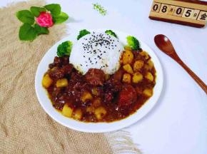 把咖喱牛肉倒入盘子的空白处。撒上熟黑芝麻，西蓝花放入，即可开吃啦！