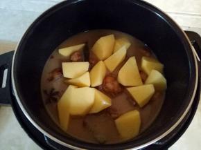 转入电压力锅中，把土豆放入，盖上锅盖，选择排骨键