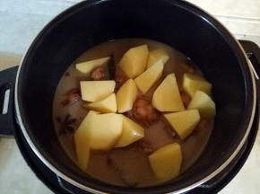 转入电压力锅中，把土豆放入，盖上锅盖，选择排骨键