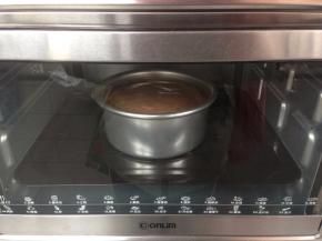 拌好的蛋糕糊从20CM左右的高度倒入到6寸的阳极活底蛋糕模里，再在桌面上震出气泡。放进已经提前预热好上火135度，下火150度的东菱K30A烤箱下层，烘烤63分钟左