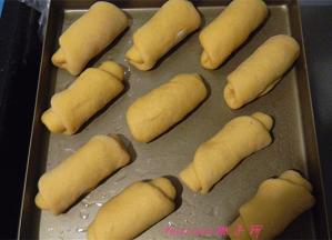 放好红豆馅，提起一端卷起，做好的面包胚放在烤盘里，包上保鲜膜二次醒发30~40分钟；