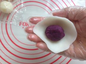 将饼皮压成圆形，放入馅料，用虎口收口，收口处多余的面团揪下来。收口处朝下