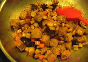 再放入烤麸、香菇和煮熟的花生翻炒，再加入红烧酱油翻炒；