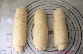 将面皮自上向下卷起，封口朝下，三个都卷好后，盖上保鲜膜静置10分钟；