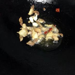 锅里倒入油，把猪肉加入翻炒变色，加入蒜和辣椒