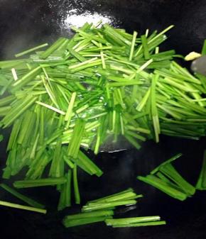 锅里流少量底油加入韭菜翻炒。（如没油了就加一些）