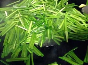 锅里流少量底油加入韭菜翻炒。（如没油了就加一些）