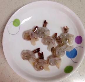 将基围虾剪去头挑去沙线，剥去虾身上的壳并保留尾部末端那一小节，再将背部剪开一个洞，将虾尾塞入洞中露出尾部做成虾球。