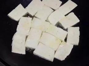 豆腐切块，放入锅中油煎至两面金黄色。
