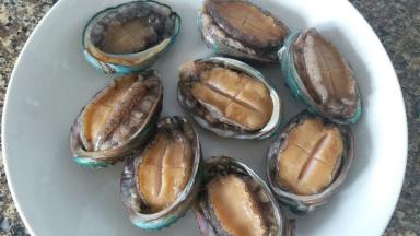 鲍鱼拉出肠子，清洗干净。用小刀在鲍鱼上划口子