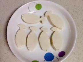 把压成鱼型的豆腐，摆放在盘子里。