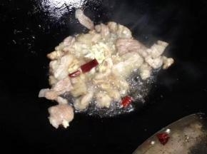 翻炒变色后，加入蒜末和辣椒炒香。