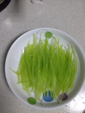 把烫好的莴笋丝铺在盘子里，备用。