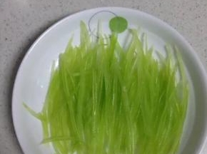 把烫好的莴笋丝铺在盘子里，备用。