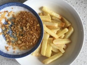 复炸好的土豆捞出沥油，倒入炸香的蒜末和油