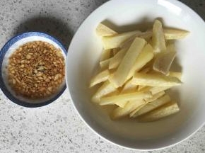 炸好的土豆条和蒜末倒入碗内