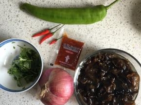 准备食材，木耳用温水泡发，香菜洗净切段，辣椒洗净切段