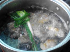 锅中加入料酒、葱段、姜片，放入蛤蜊煮